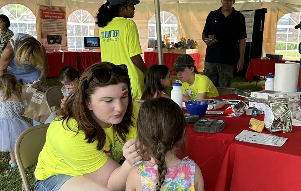 Volunteers paint faces at Family Fun Festival in 2023
